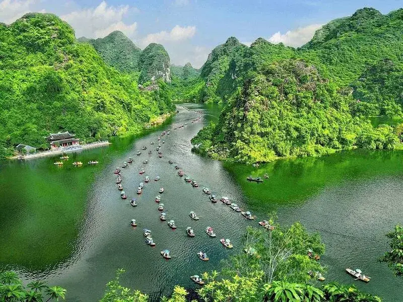 Small boats moving through the limestone waterways of Trang An