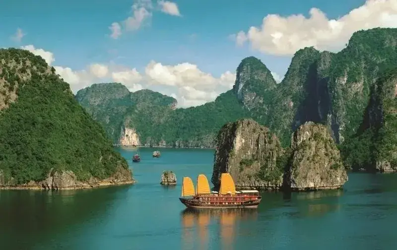 Traditional cruise boat among limestone islands in Ha Long Bay