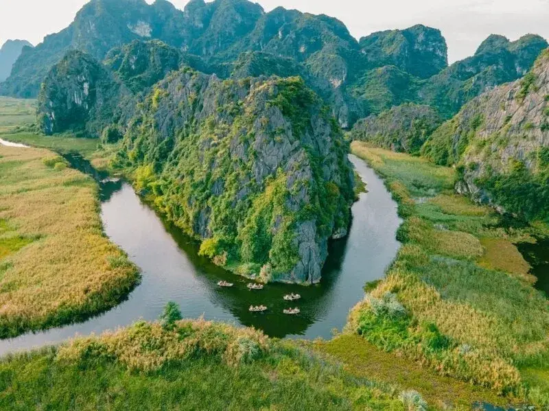 Small rowing boats moving through Van Long Wetland in Ninh Binh