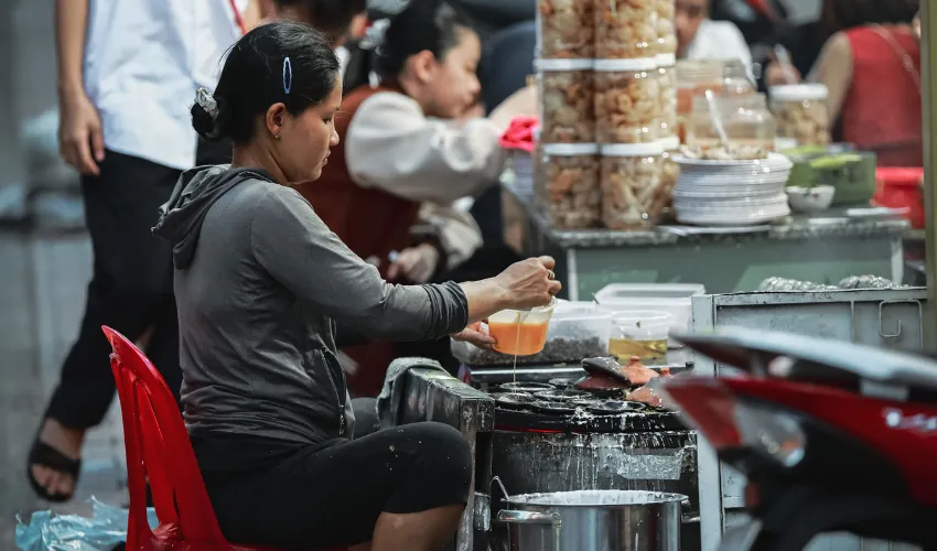 Local vendor preparing food at a market in Nha Trang Vietnam