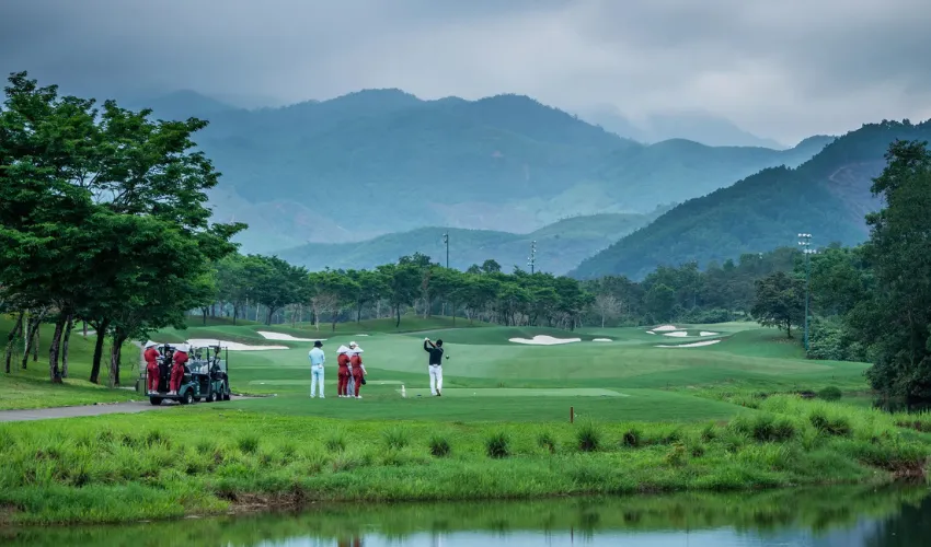 Golfer and caddies enjoying a golf tour at Ba Na Hills in Da Nang Vietnam