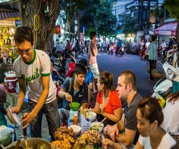 Tourists enjoying guided street food tour in Hanoi
